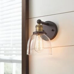 Evelyn 6 in. 1-Light Bronze Modern Industrial Wall Mount Sconce Light with Clear Glass Shade by Home Decorators Collection -Outlet Home Decorators Collection Store artisan bronze home decorators collection vanity lighting hb15018 313 4f 1000